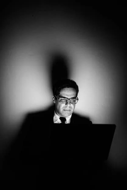 A businessman looking intently at his laptop, while a shadowy figure in a hoodie looms behind him, symbolizing the hidden threats of phishing and BEC. The lighting is dim, adding to the sense of conspiracy.