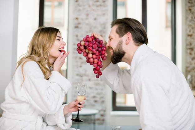 A couple celebrating an anniversary in a luxurious hotel room, with champagne and flowers, enjoying the moment.
