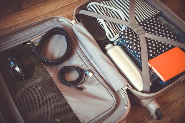 A neatly organized luggage with clothes rolled and packed in cubes, next to a passport and a travel-sized toiletries bag.