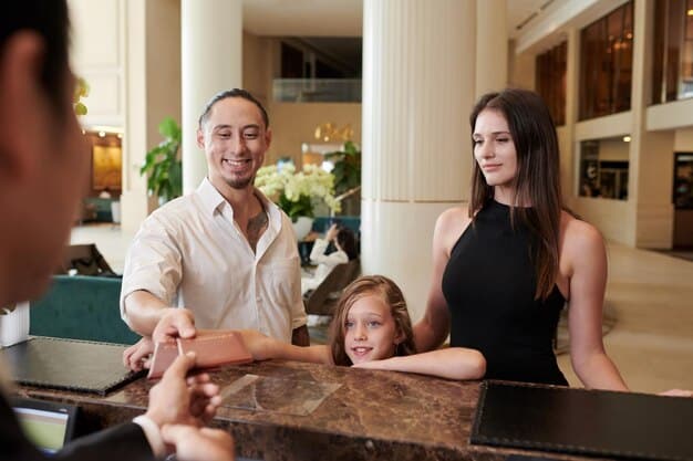 A family of four excitedly checking-in at a hotel reception, signifying the successful redemption of hotel points for a luxurious stay.