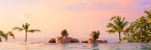 A couple enjoying a private infinity pool overlooking a tropical beach during sunrise, illustrating a luxurious and private travel experience.