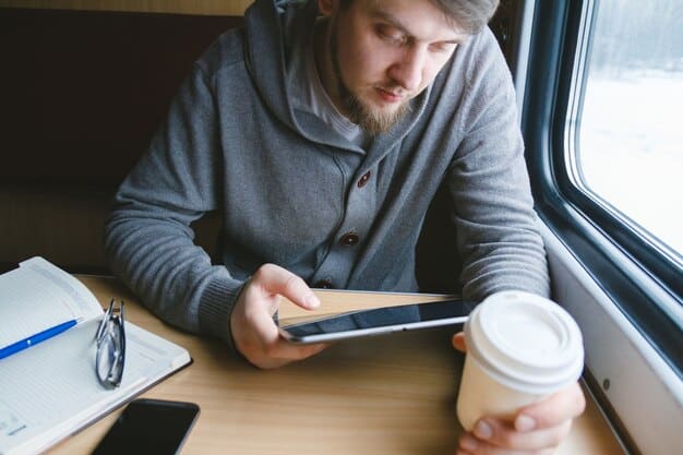 A person meticulously categorizing digital receipts on a tablet, with a cup of coffee nearby, emphasizing the disciplined approach required for effective expense reporting in business travel hacking.