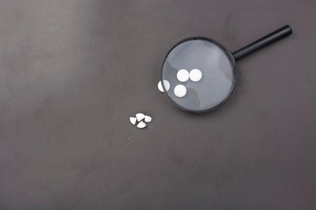 A magnifying glass hovering over a credit card and a pile of medical records, highlighting the sensitive nature of financial and health personal information and the need for close inspection against theft.