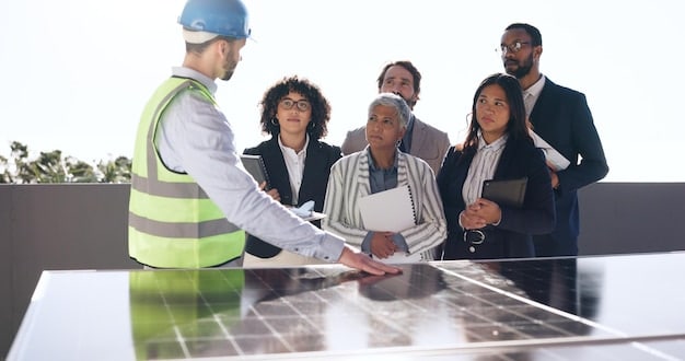 Diverse group of people in hard hats and safety vests discussing blueprints on a construction site for a new solar array. The atmosphere is collaborative and professional.