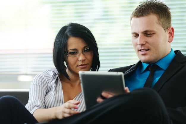 Two people, a financial advisor and a client, reviewing documents on a tablet and laptop, symbolizing a collaborative financial planning session.