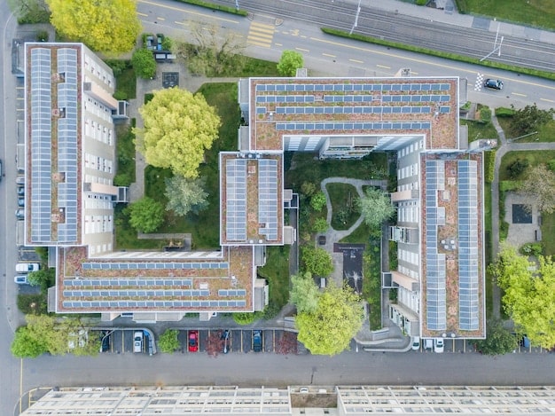 A detailed architect's rendering showing a modern, mixed-income housing complex with green spaces, solar panels, and bicycle racks, indicating sustainable living.