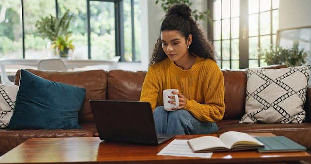 A student using a laptop in a comfortable home setting, engaged in an online lecture, with a coffee mug, highlighting remote learning convenience.
