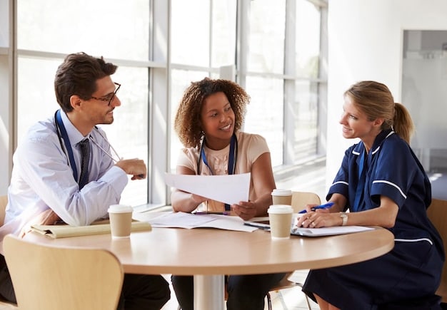 A group of diverse people discussing and looking at health insurance documents around a table, with a confident and hopeful expression.