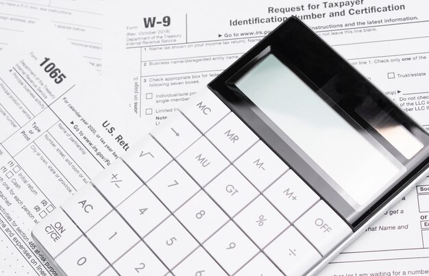 A magnifying glass hovering over a tax form with 