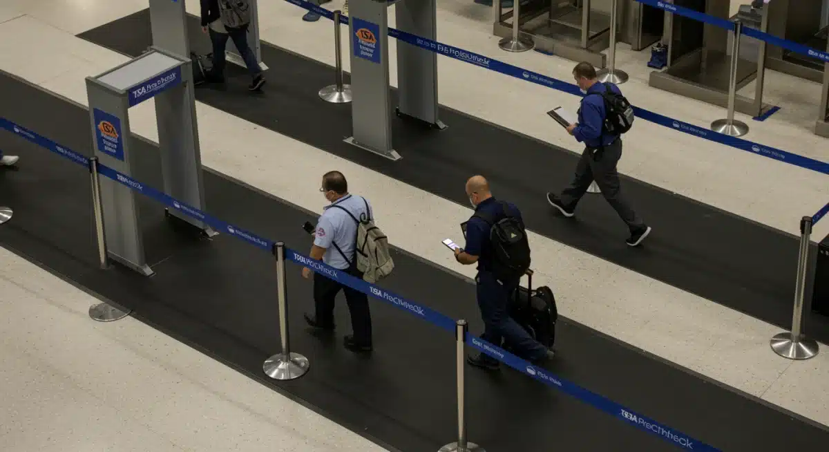 Passengers utilizing a TSA PreCheck lane for faster security screening at a US airport.